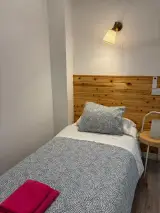 Baño de la Habitación Individual con lavabo, espejo iluminado, secador de pared y toallas amarillas